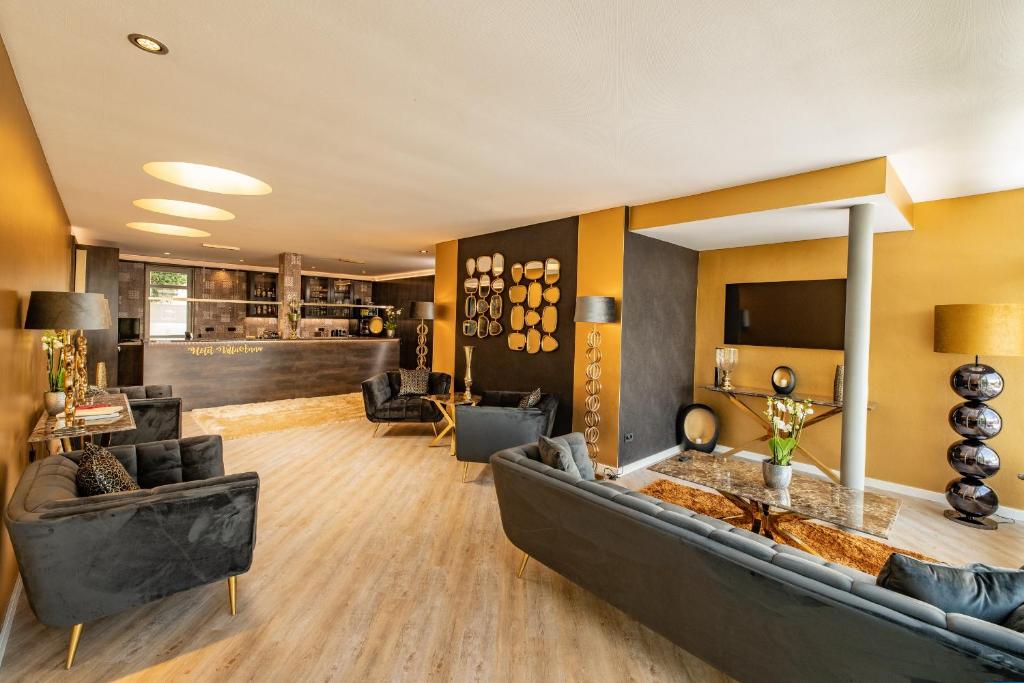 ein großes Wohnzimmer mit einem Sofa und Stühlen in der Unterkunft Boutique-Hotel Villa Anna in Eisenach