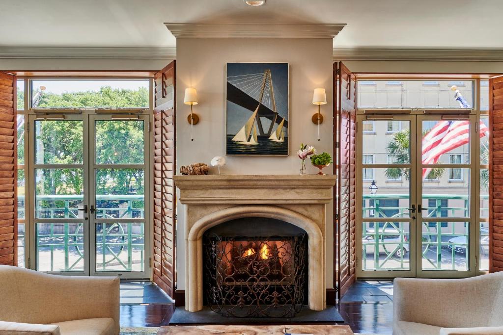 a fireplace in a living room with windows at Harbourview Inn in Charleston