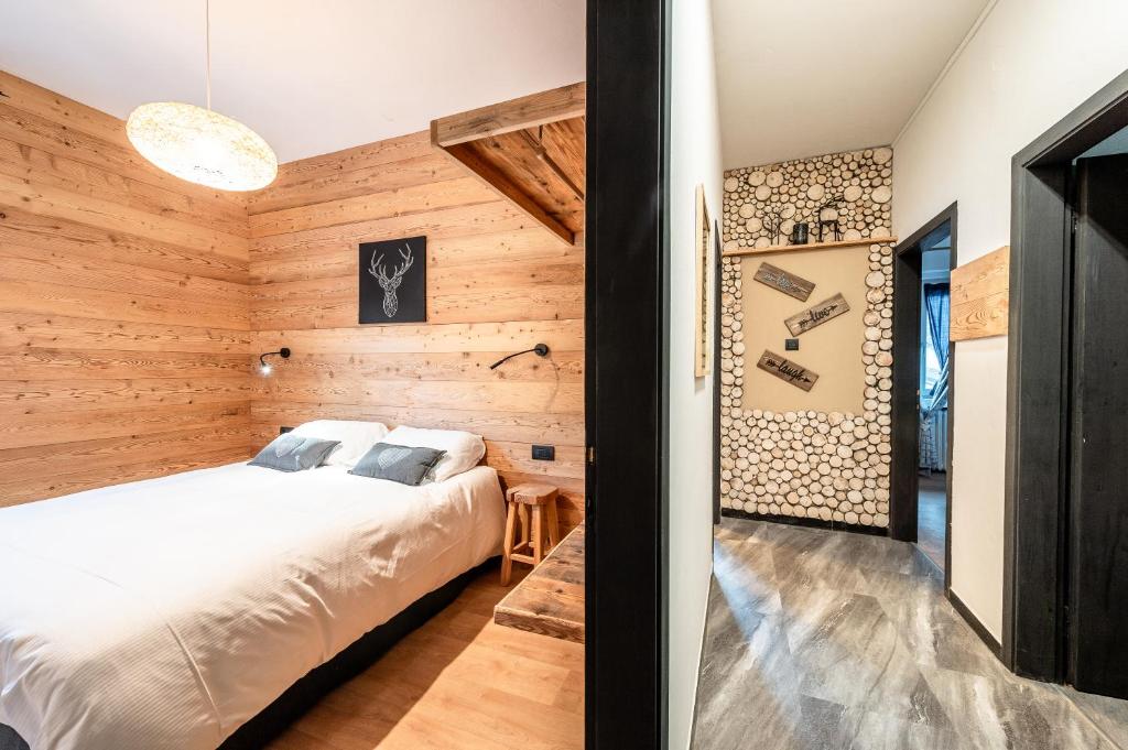 a bedroom with a bed and a wooden wall at -Antermoia- Appartament Canazei Center in Canazei