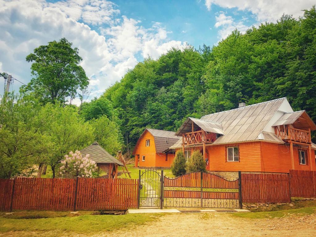 una casa naranja con una valla delante de una montaña en Cottage v Gorakh, en Izky