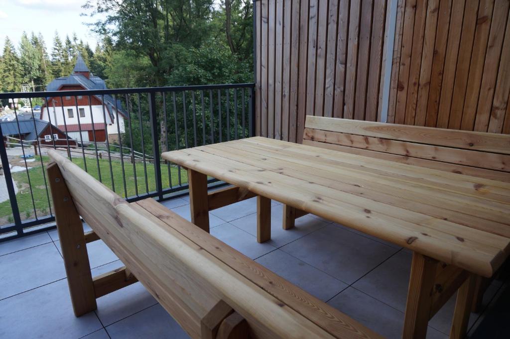 a wooden bench sitting on top of a balcony at Apartmán Čihadla in Bedřichov
