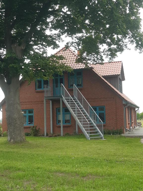 a brick house with a staircase in front of it at Ferienwohnung Wald und Weitblick in Dreschvitz