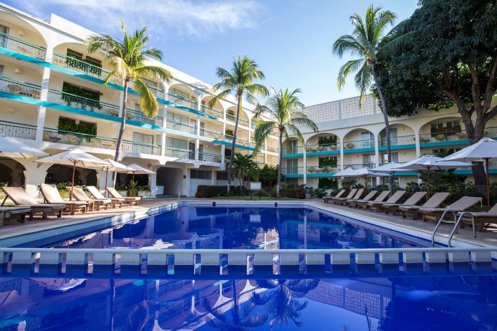 a swimming pool in front of a hotel at Hotel Suites Villasol in Puerto Escondido