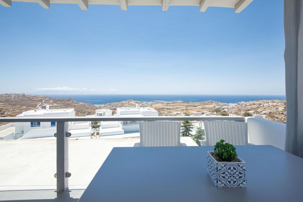 un tavolo blu su un balcone con vista sull'oceano di Elma’s Summerhouses a Mykonos Città