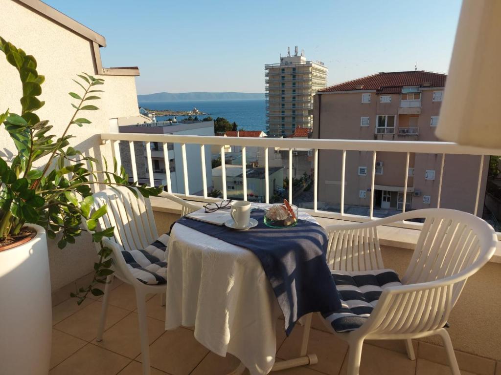 a table and chairs on a balcony with a view at Apartments Ema near beach in Makarska