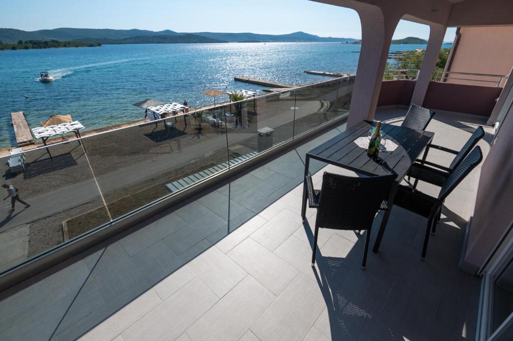 d'un balcon avec une table et des chaises et une vue sur l'eau. dans l'établissement Euroholiday apartments, à Turanj