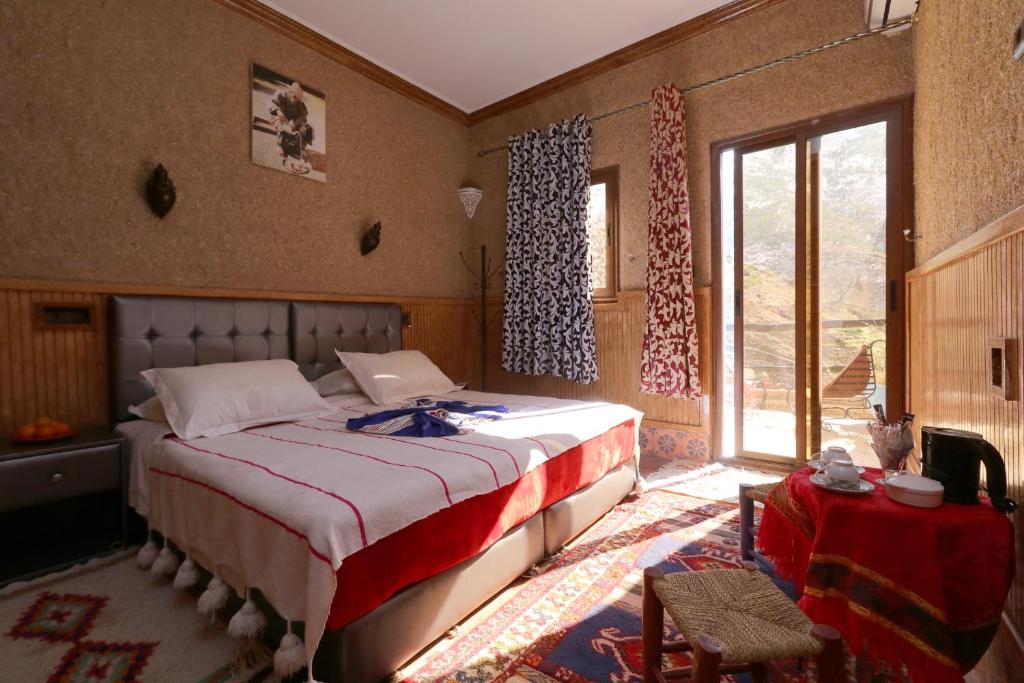 a bedroom with a bed and a large window at Toubkal Garden in Imlil