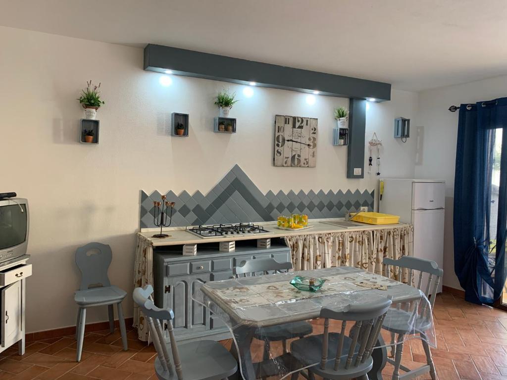 una cucina con tavolo, piano cottura, tavolo e sedie di Appartamento Martina2 a Codaruina