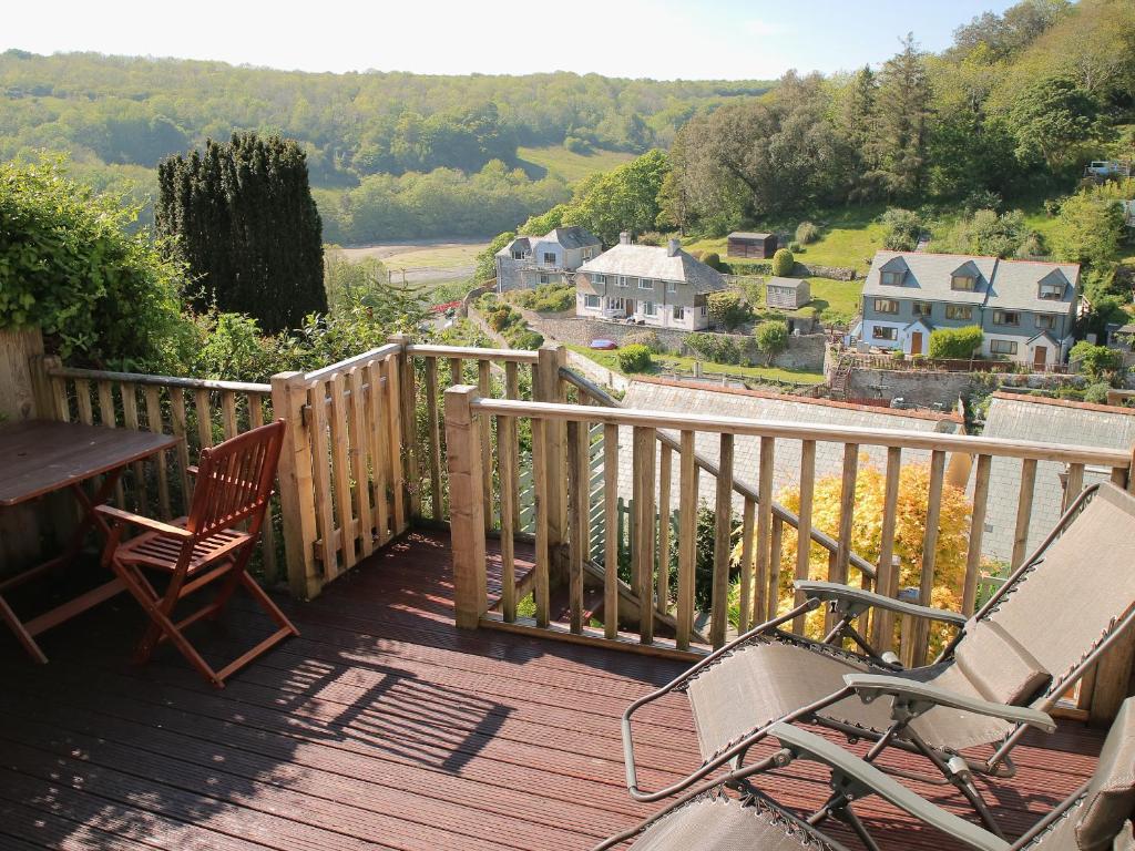 a wooden deck with two chairs and a table on it at Lowena Cottage in Looe