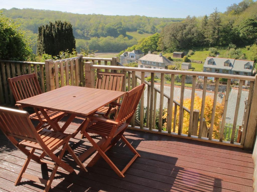 a wooden table and two chairs on a deck at Lowena Cottage in Looe