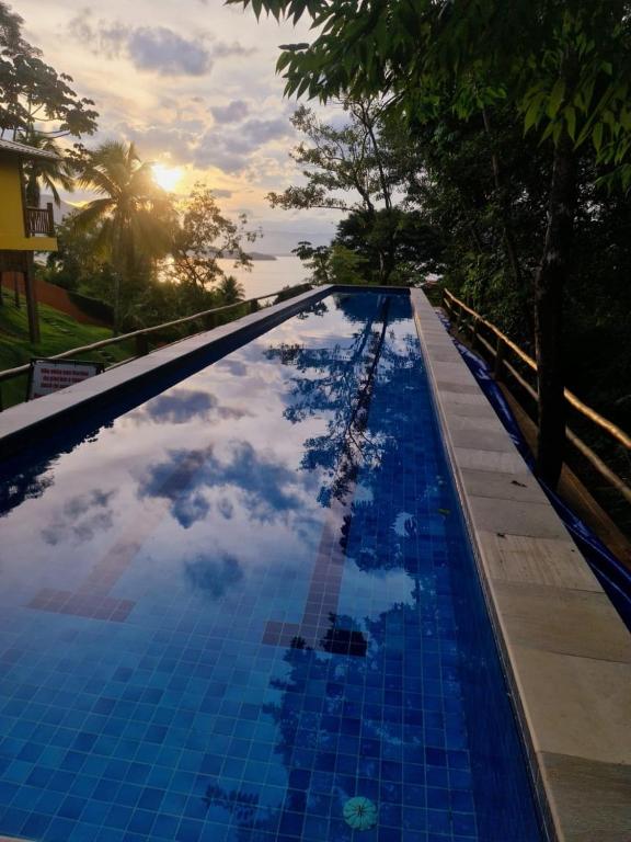 a pool with a reflection of the sky in the water at Siriúba Reserve in Ilhabela