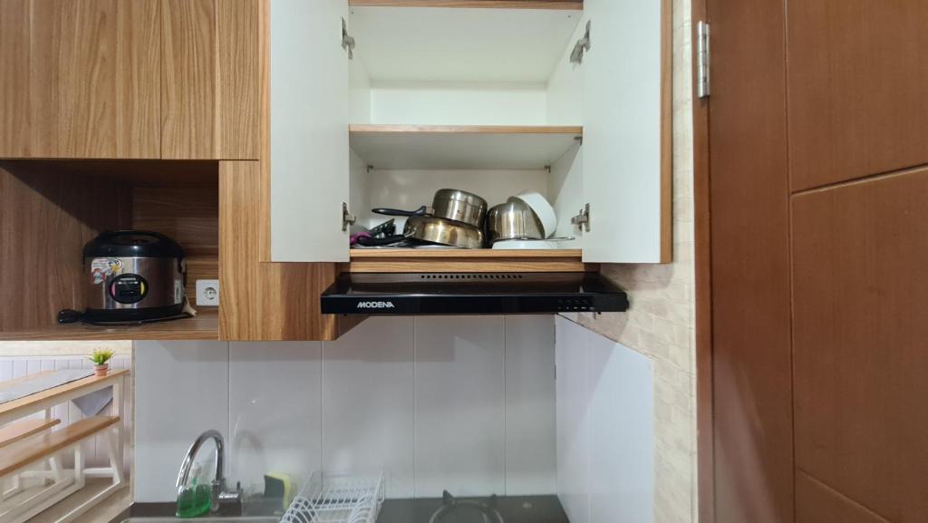 万隆Gateway Pasteur 2BR tower depan Ruby 7 C的厨房配有带锅碗瓢盆的白色橱柜
