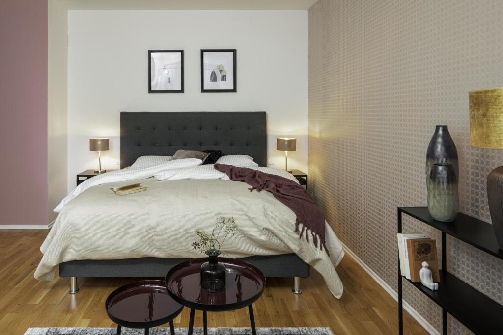 a bedroom with a large bed and two tables at Sophisticated Condo in Nusle by Prague Days in Prague