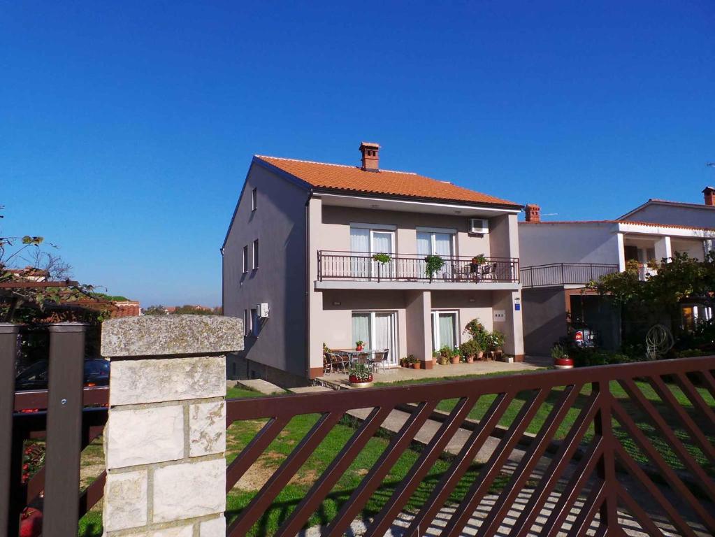 a house with a wooden gate and a fence at Apartment Valbandon 9 in Fondole