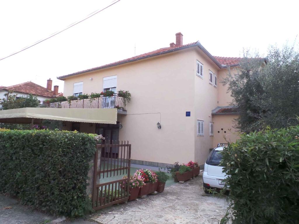 una casa bianca con una macchina parcheggiata di fronte di Apartment Zadar, Zadar County 8 a Smirić