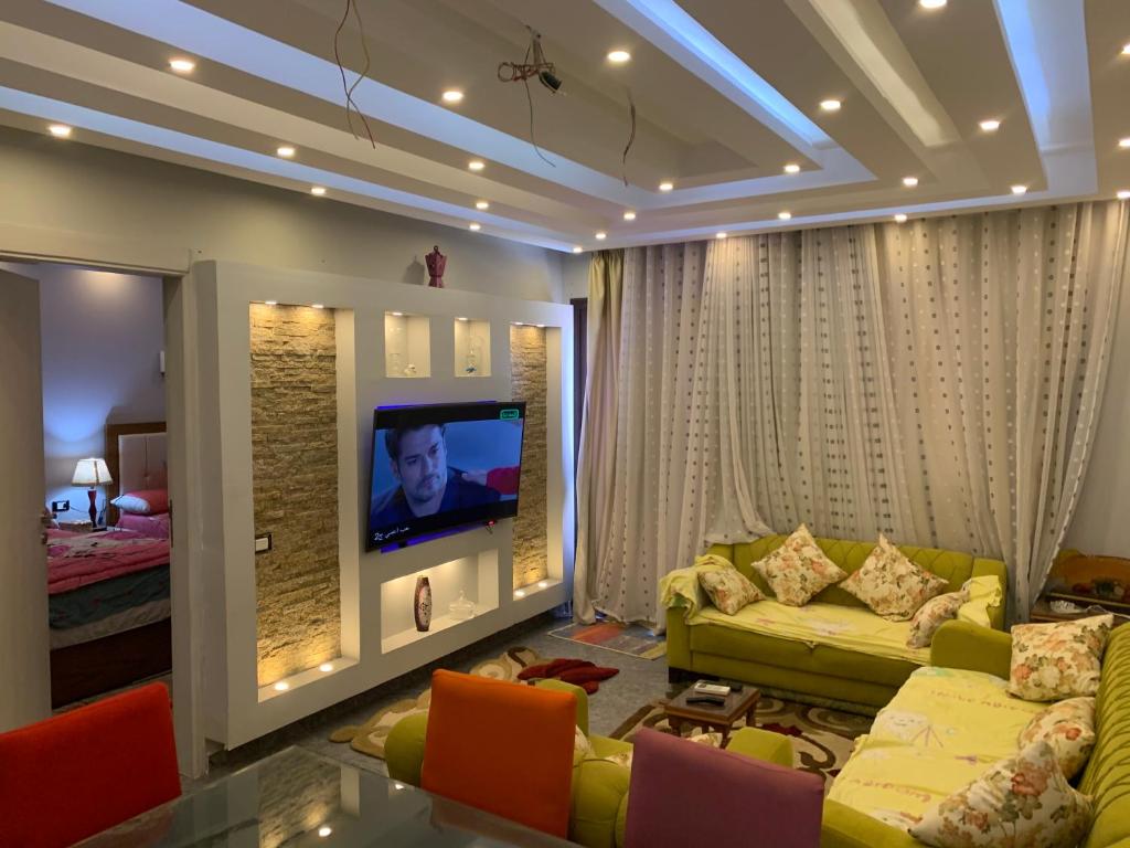 Chalet stella makadi family only في الغردقة: غرفة معيشة مع أريكة وتلفزيون