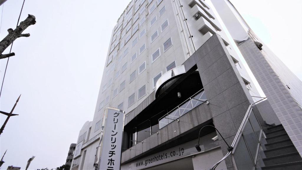 a tall building with a sign on the side of it at Green Rich Hotel Suizenji in Kumamoto