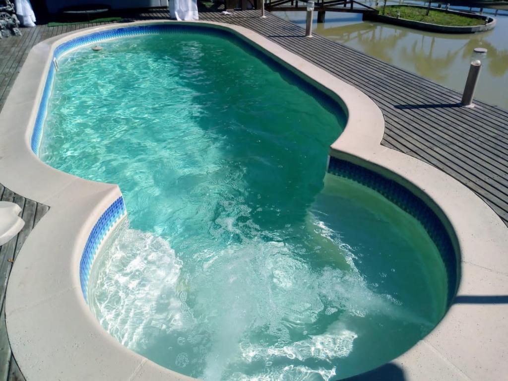 uma banheira de hidromassagem com água verde numa piscina em Sítio com belíssima paisagem para relaxar em Cobras