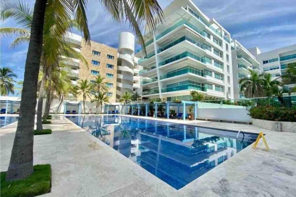 a swimming pool in front of a large building at Apartamento Cartagena en Morros frente a la playa in Cartagena de Indias
