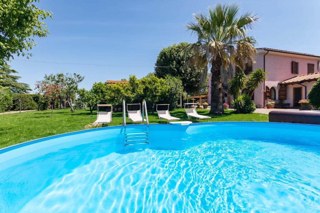 una piscina con sillas en un patio en Hostly - Country House Donoratico - ONLY FOR FAMILIES, en Donoratico