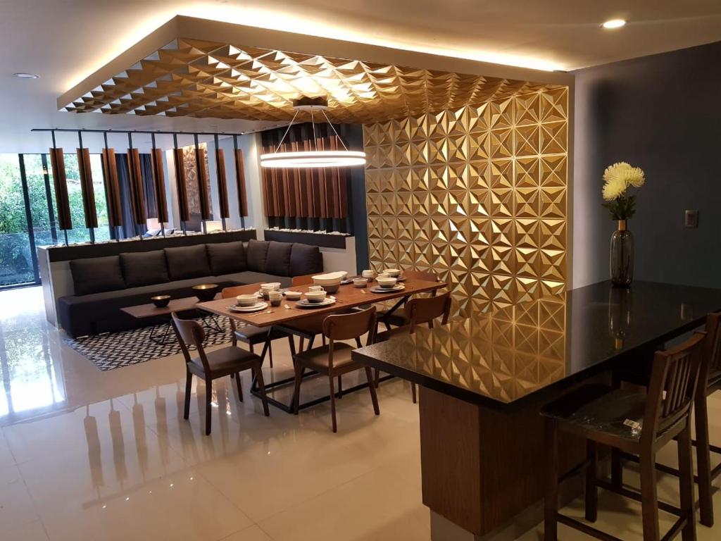 a dining room with a table and a couch at Business SUITES KEPLER in Mexico City