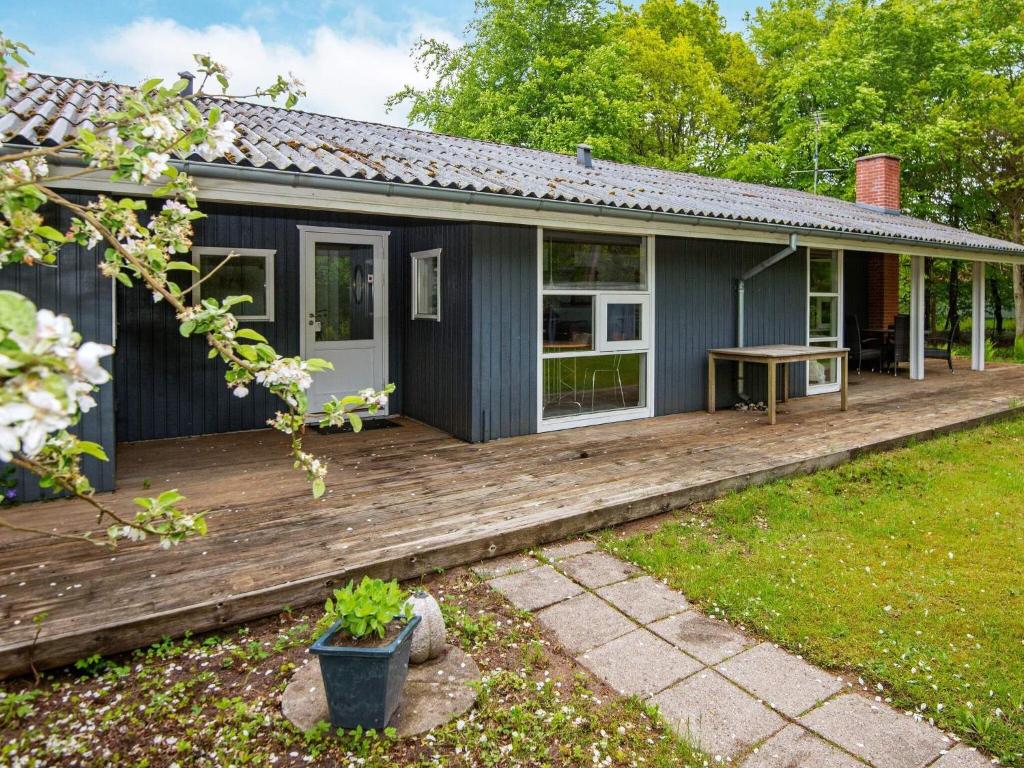 una casa con terraza de madera en el patio en 6 person holiday home in Glesborg en Fjellerup Strand