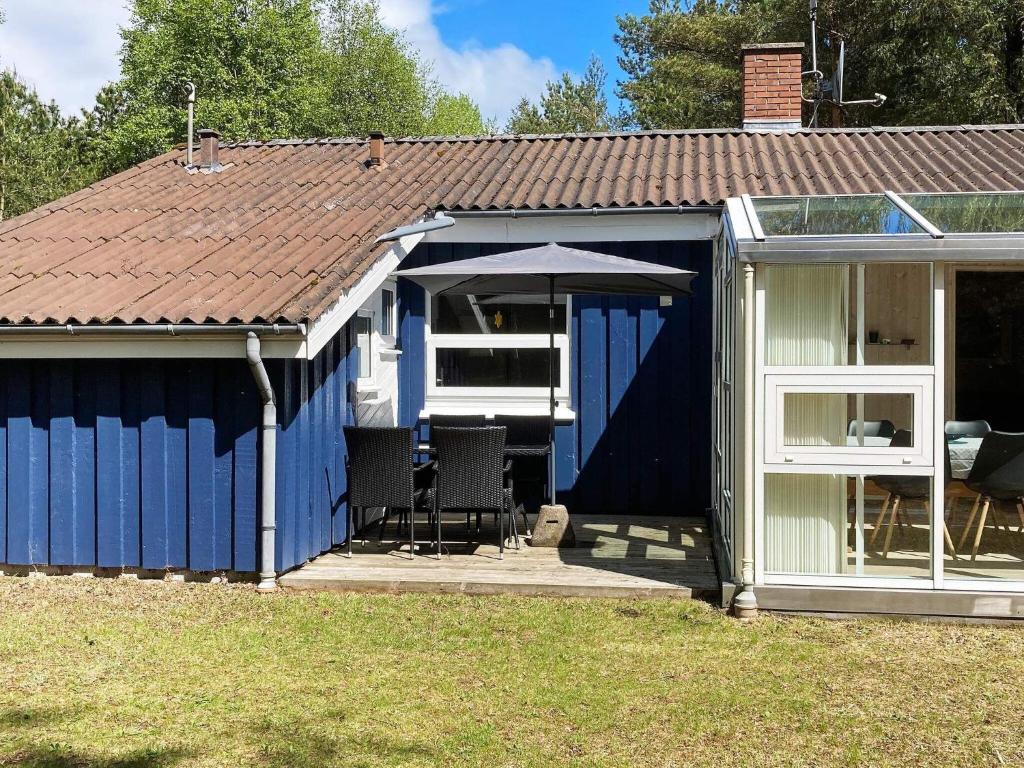 un cobertizo azul y blanco con techo en 8 person holiday home in Hadsund, en Odde