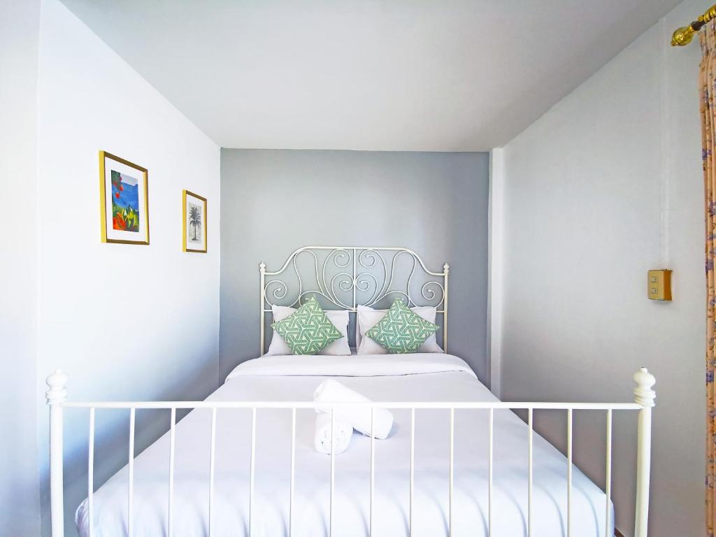 a bedroom with a white bed with a white crib at ระเบียงทะเล รีสอร์ท in Phetchaburi