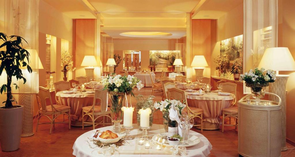 a banquet hall with tables with flowers and candles at Hotel Komeda in Ostrów Wielkopolski