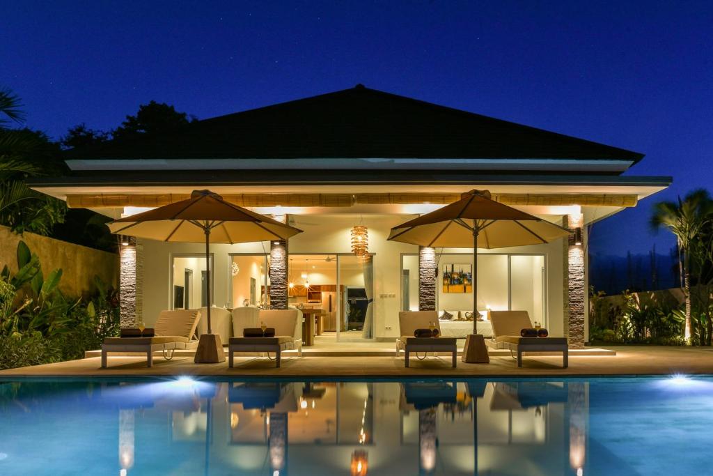 a villa with a swimming pool at night at Villa Saneva in Buleleng