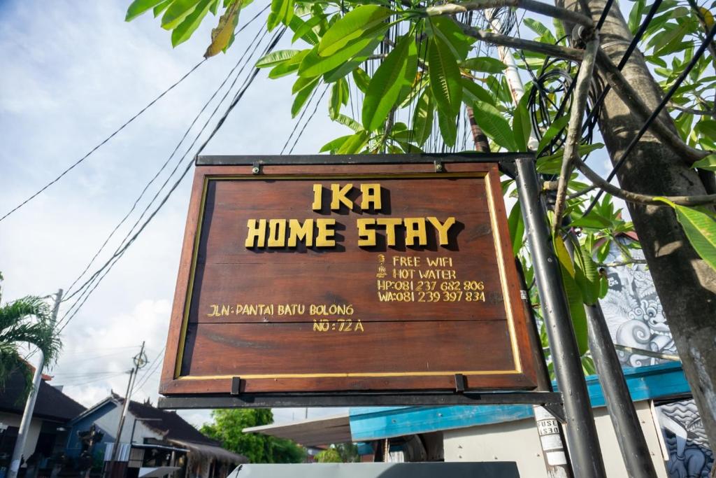 a sign for a home stay on a street at Ika Homestay in Canggu