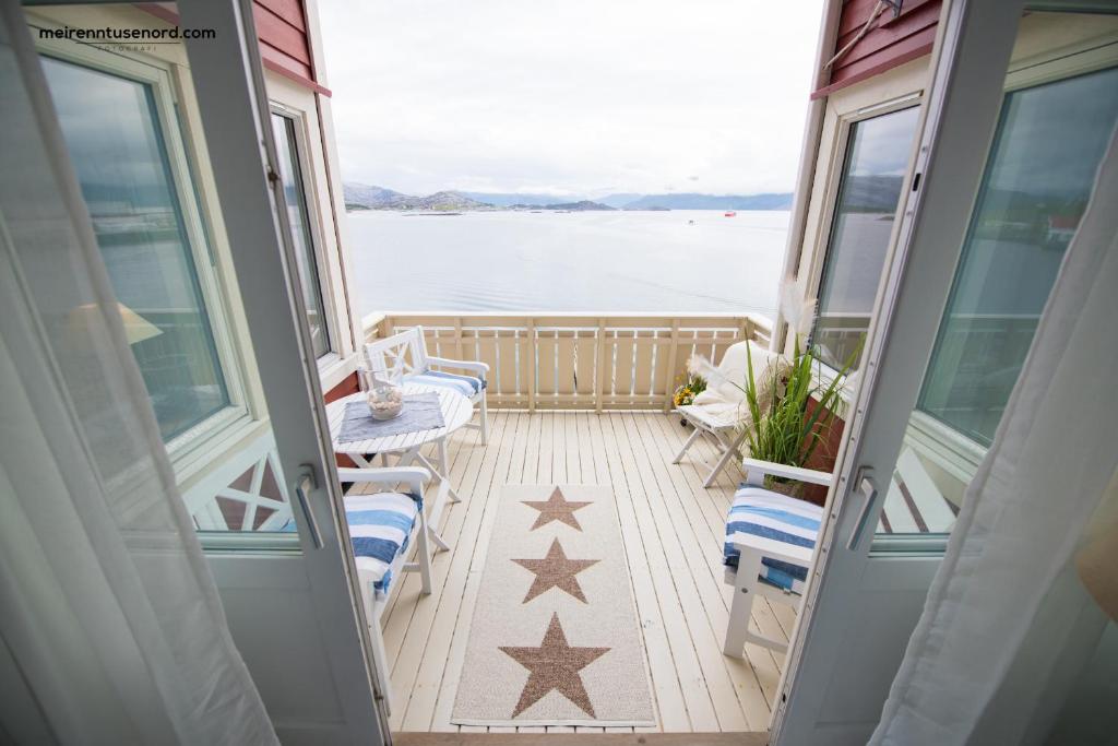 a balcony on a cruise ship with a table and chairs at Kalvåg Holidayapartment in Kalvåg
