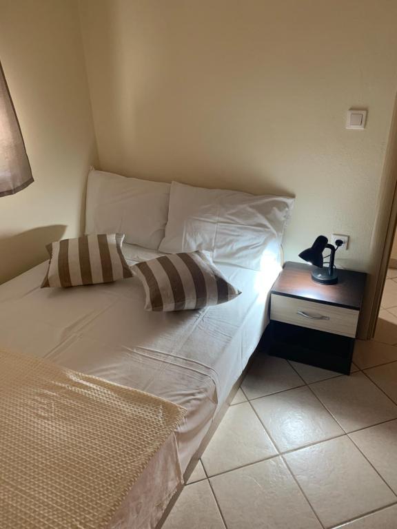 1 cama con 2 almohadas y una lámpara en una mesa en Seaside Folia Beach Kavala, en Loutrá Elevtherón