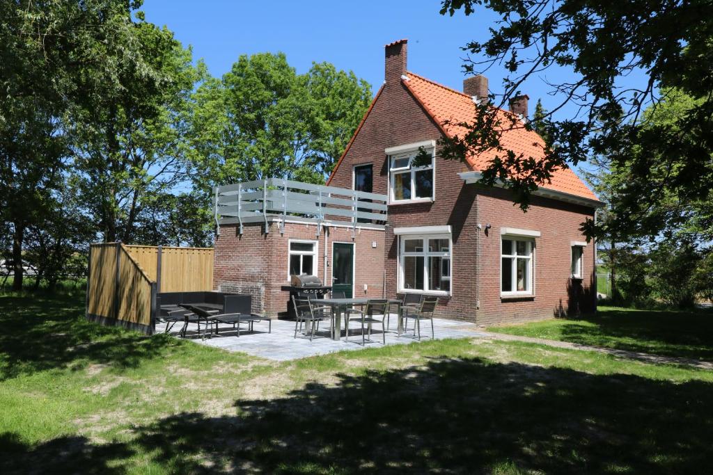 a brick house with a patio in front of it at Hof Suzanna in Arnemuiden