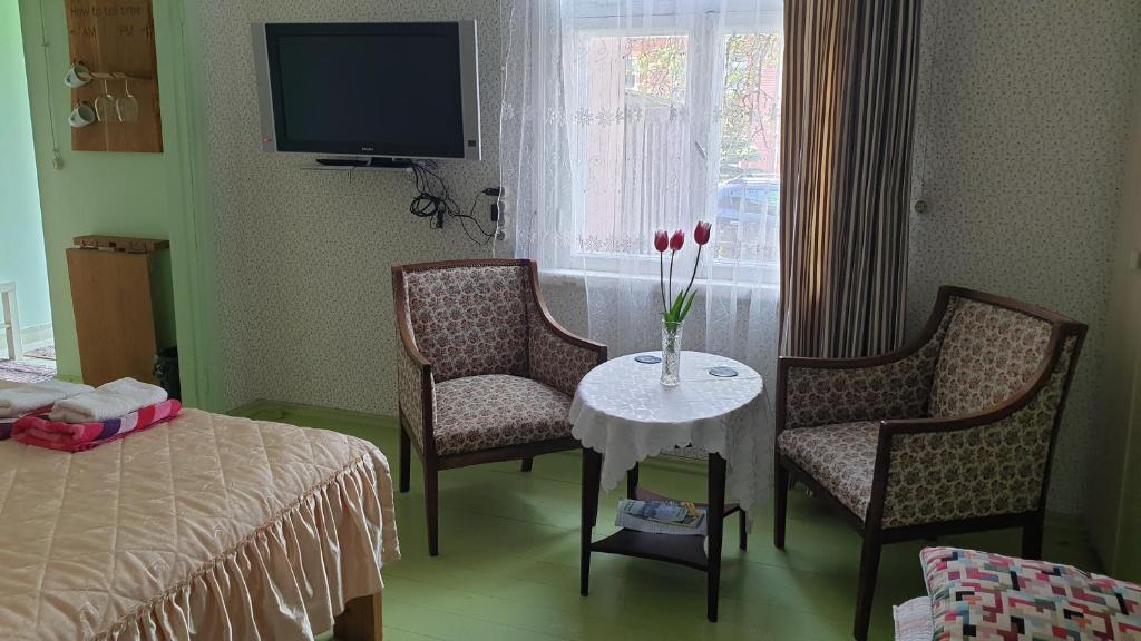 a room with two chairs and a table and a bed at Romantisks apartaments ar lapenīti G18 in Līgatne