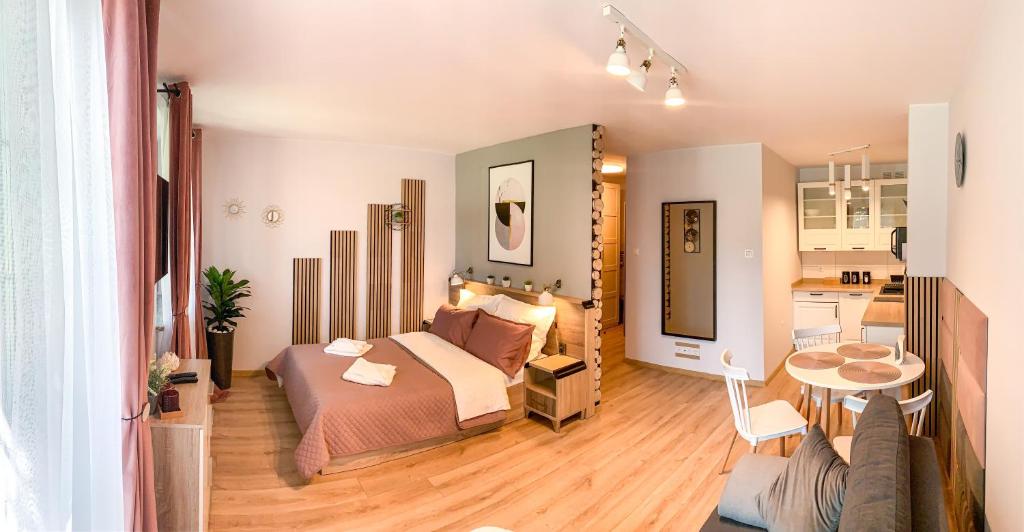 - une chambre avec un lit et un salon dans l'établissement apartament Forest Karpacz, à Karpacz