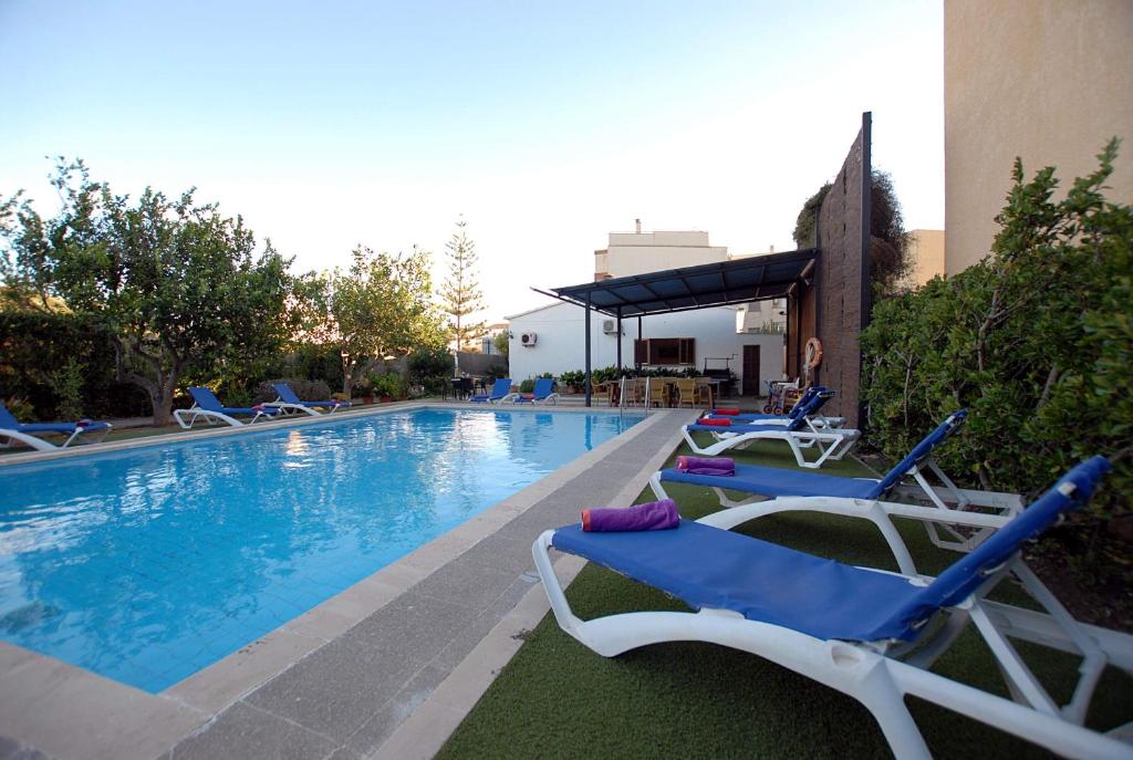 una piscina con tumbonas junto a un edificio en Villa Torrent, en Puerto de Alcudia