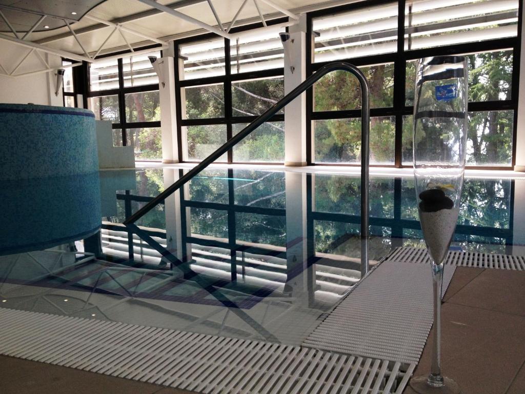 a room with a glass window with a bath tub at Hotel Flores in Poreč