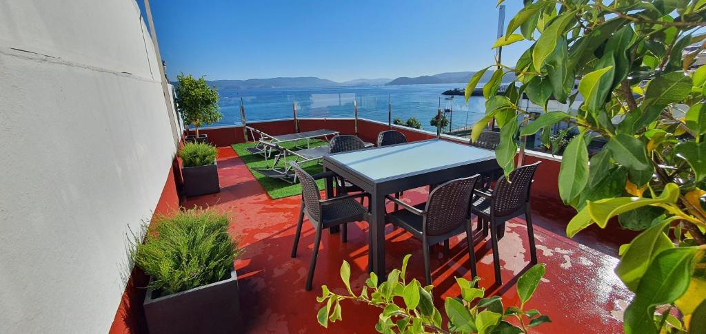 Un patio con una mesa y sillas en un balcón. en Casa da Banda, en Bueu