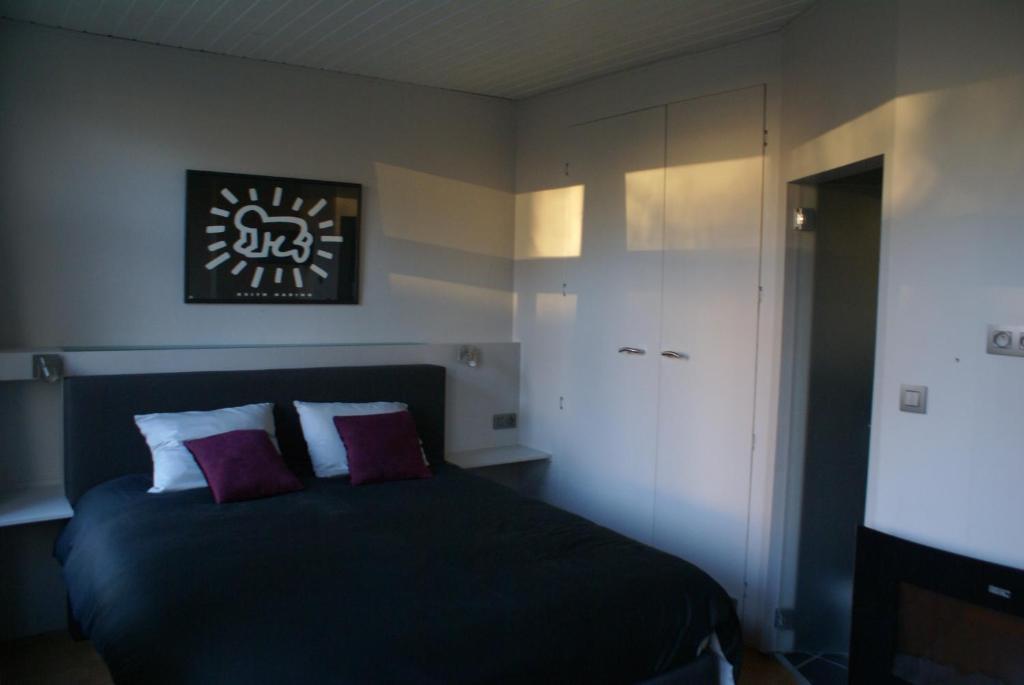 a bedroom with a black bed and a white cabinet at Guest House Feliz in Leuven