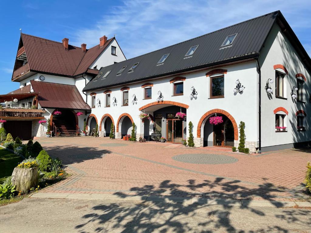 a large white building with a black roof at U Kowola - Gospodarstwo Agroturystyczne in Węglówka