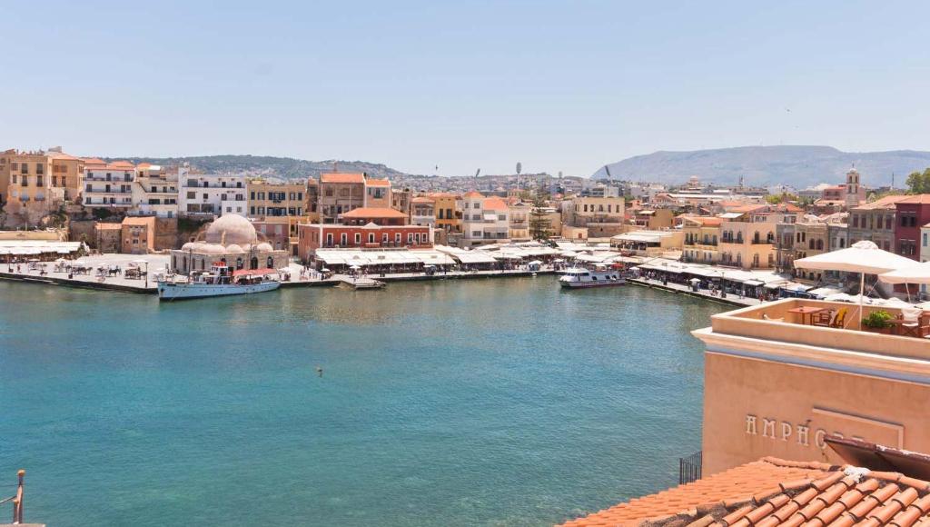 Blick auf einen Fluss mit Booten in einer Stadt in der Unterkunft Helena Hotel in Chania