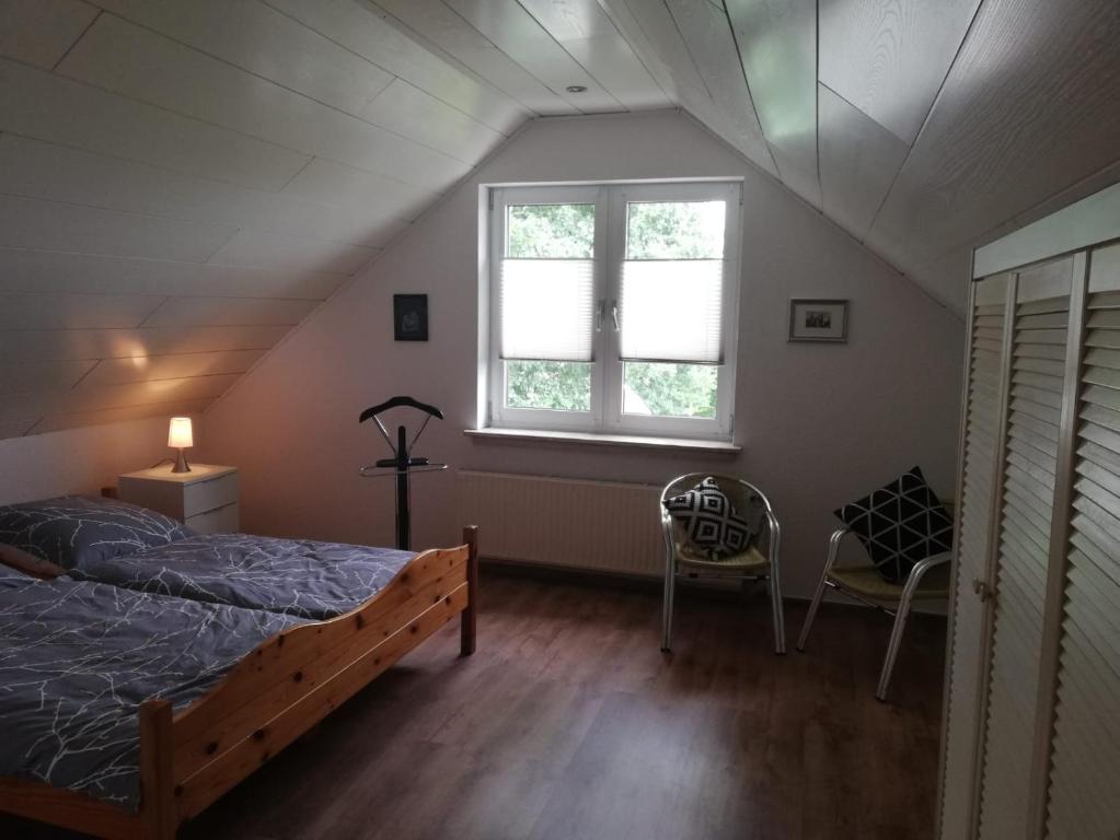 - une chambre avec un lit, une fenêtre et une chaise dans l'établissement Ferienhaus Domus, à Xanten