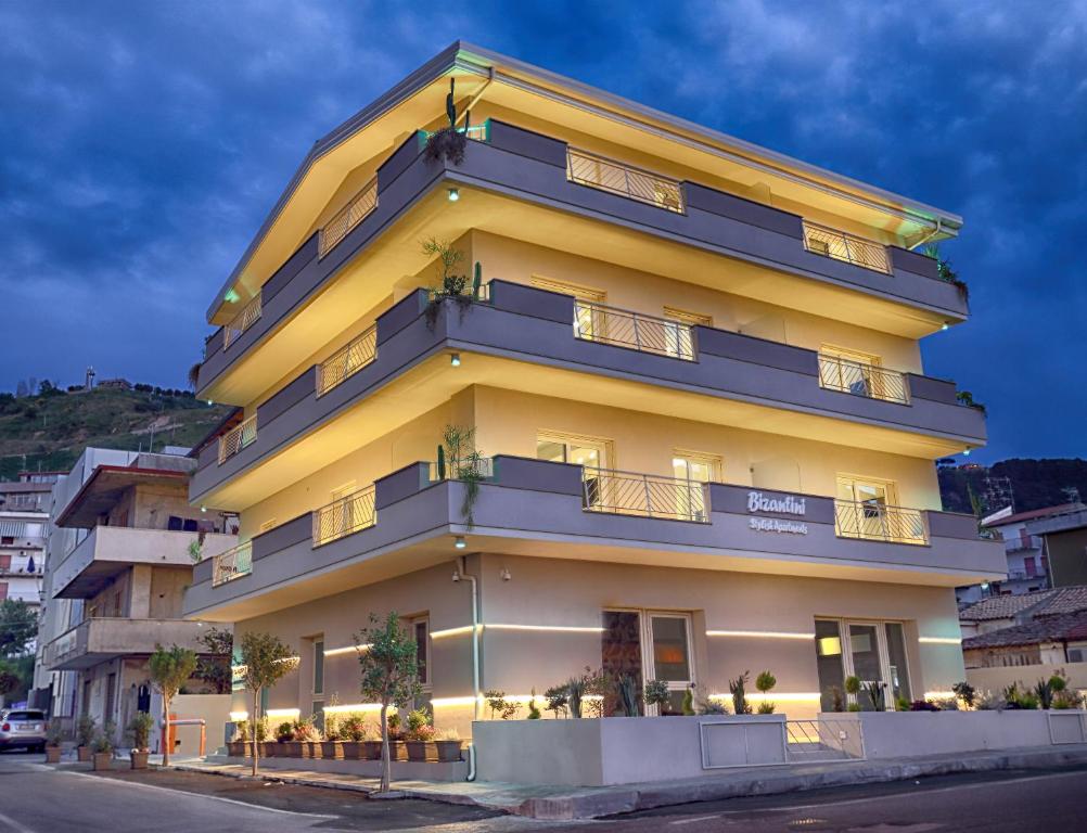 a tall yellow building with plants in front of it at Bizantini Tropea in Tropea