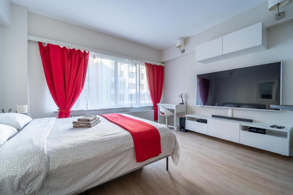 1 dormitorio con 1 cama grande y cortinas rojas en Luxury Studio In the EU Area en Bruselas