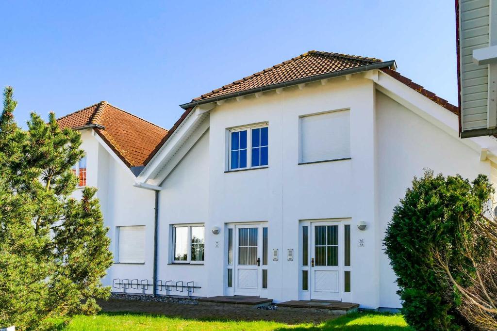 a white house with a red roof at Ferienwohnungen Max und Moritz in Neddesitz