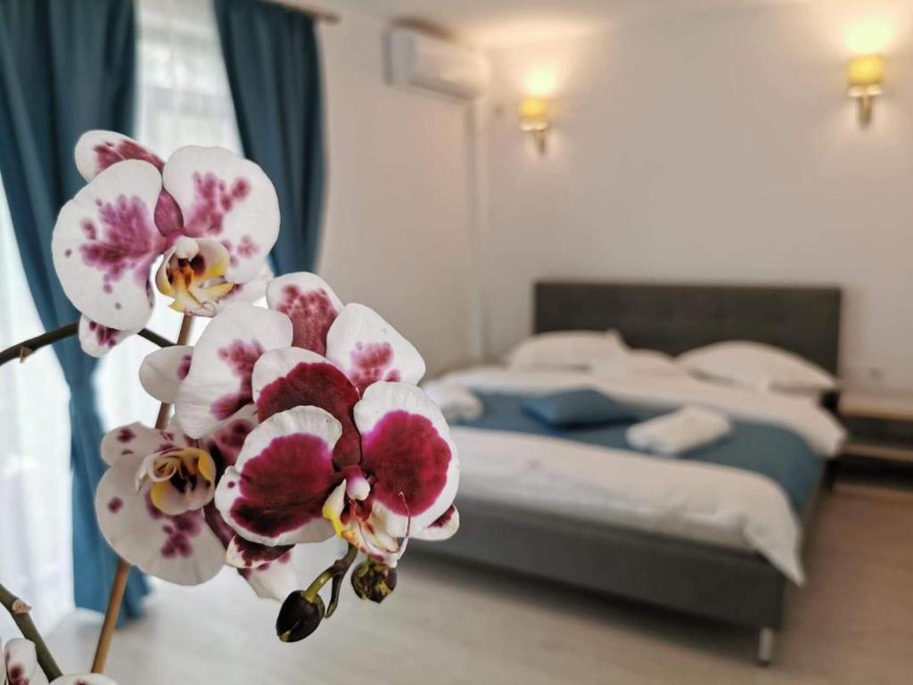 a bedroom with a bed and a flower in the foreground at Casa Loro in Eforie Sud