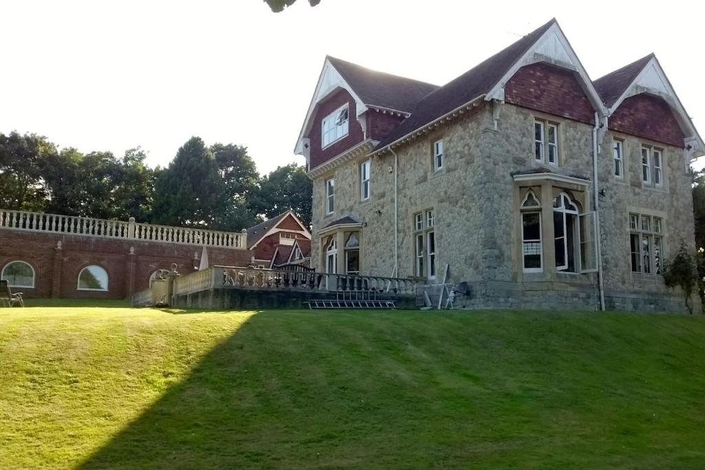 a large brick building with a clock on the side of it at Country Manor House with indoor pool and hot tub in Rochester