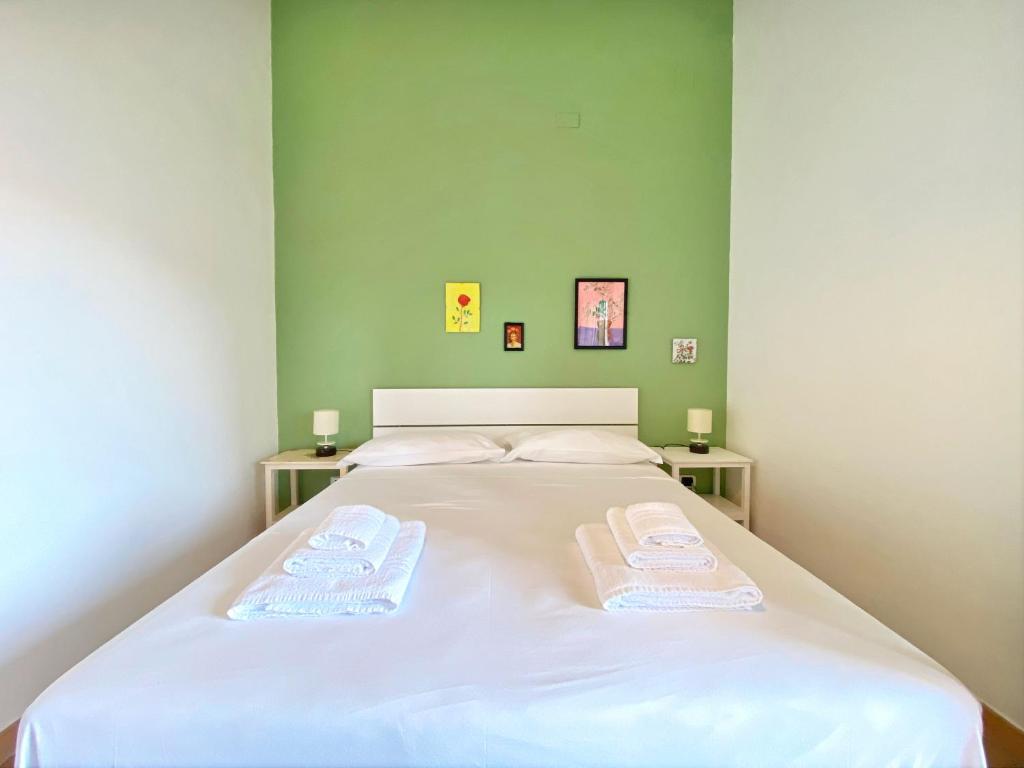 una camera da letto con un grande letto bianco con due asciugamani di Giannì Holiday Home - Vesuvio/Pompei a Terzigno