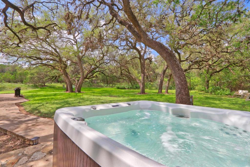 a hot tub in a garden with trees in the background at Arbor Creek in Wimberley